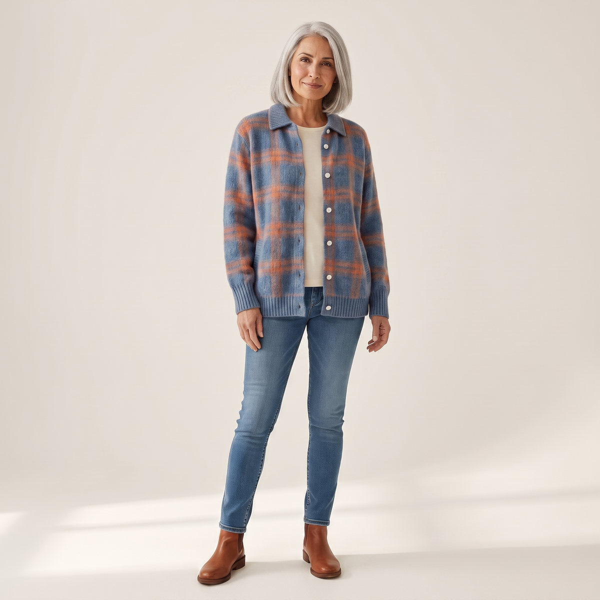 Woman wearing the Aura brushed plaid shirt cardigan open over a cream top with blue jeans, front view
